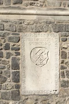 A stone plaque with Gothic script is set into a stone wall. in Brno, Czech .. Stock Photos