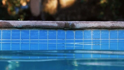 Stone pool side with blue tiles - Blue water reflection Stock Footage 107168051