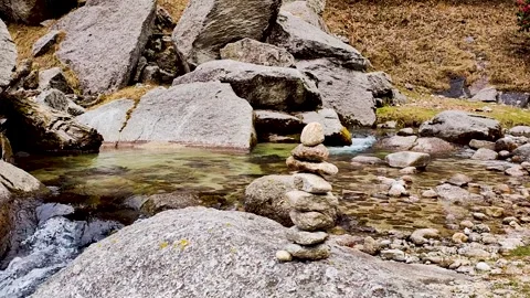 Stone pyramid clean water splash stream in the rocks at mountain waterfall Video stock 305409285
