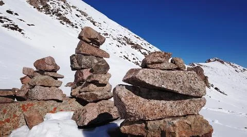 Stone pyramid pointer tour in the snowy mountains Stock Photos
