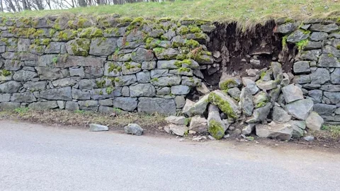 Stone retaining wall collapse on roadside caused by erosion 库存影片 331719820