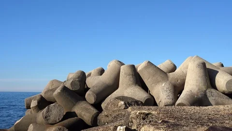 Stone rocks of massive triangular shape fortificating sea shore, protecting and Video stock 127307423