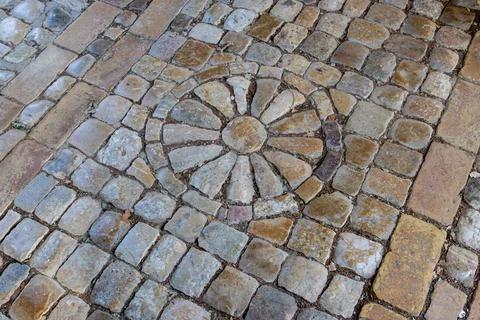 Stone rosette pattern in historic cobblestone pavement 库存照片