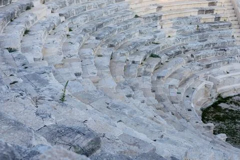 Stone seating rows of an ancient Greco-Roman amphitheater in ruin 스톡 사진