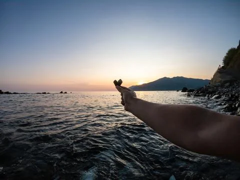 Stone in the shape of a heart on a sunset background. stone heart in hand Stock Photos