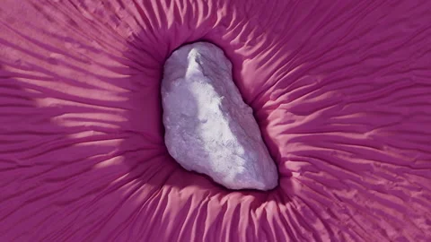 Stone sinking into purple fabric Stock Footage 253636000