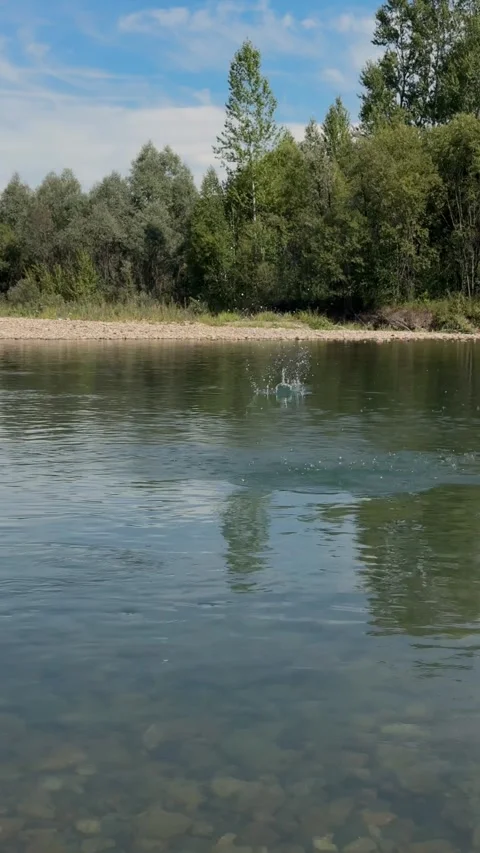 Stone Skipping Across a Calm River Видео 345550932