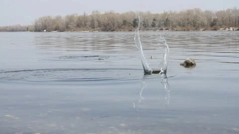 Stone skipping on water surface Video stock 124603721