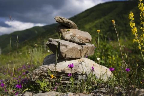 Stone stack with balanced stones on blurred mountain background Stock Photos