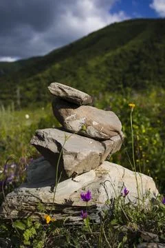 Stone stack with balanced stones on blurred mountain background. Vertical sho Stock Photos
