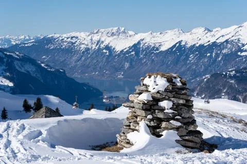 Stone stack in bernes alps with snow caped mountains and lake brienzersee. Stock Photos