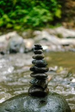 Stone stack by flowing river in nature. Stock Photos