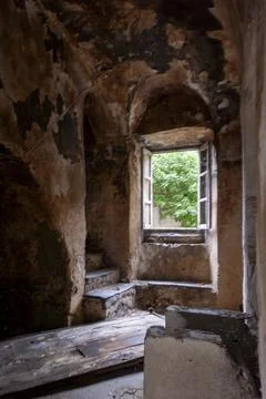 Stone staircase and open window in deteriorated ancient interior Stock Photos