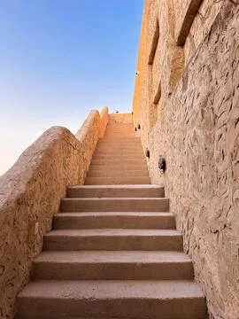 Stone staircase leading up between old beige walls Stock Photos