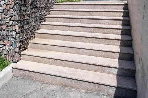 Stone staircase with massive steps made of polished stone slabs in a landscaped Stock Photos