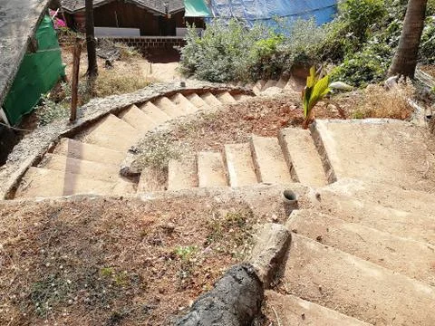 A stone staircase winds down towards the sea Stock Photos