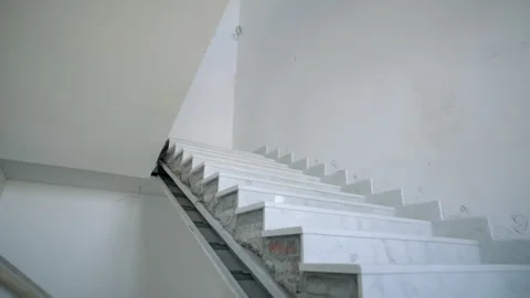Stone staircase winds upward between plastered walls Stock Footage 335644389