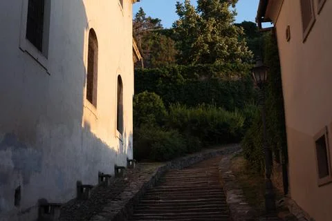 Stone staircase winds upward between historical buildings Stock Photos