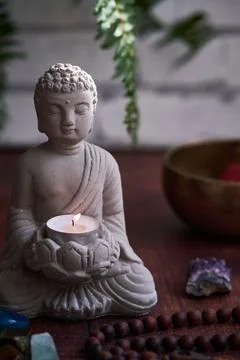 Stone statue of buddha with a candle Stock-Fotos