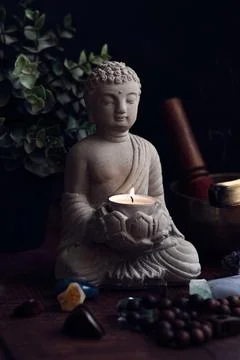 Stone statue of buddha with a candle Foto stock