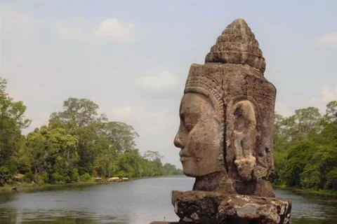 Stone statue Deva at the south gate of Angkor Thom, Angkor Wat. Overlooking t 库存照片