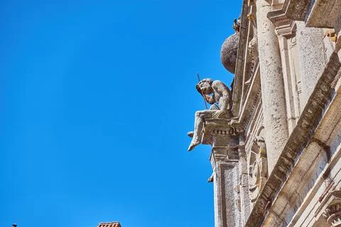 Stone statue sitting on cathedral facade Stock Photos