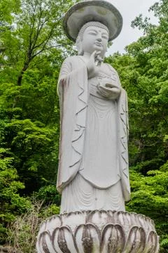 Stone statue of standing Buddha. Stock Photos