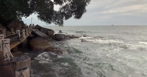 Stone steps descend over wet rocks to the turbulent sea. Stock Footage 317212426