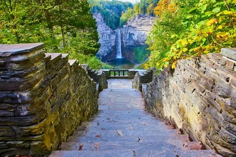 Stone steps lead down to overlook of huge waterfall into canyon surrounded by Stock Photos