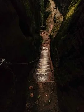 Stone steps wind down a narrow canyon, shaded by tall rock walls Stock Photos