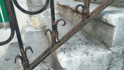 Stone steps worn down from foot traffic. Old stone stairs with rusty wrought Stock Footage 233036562