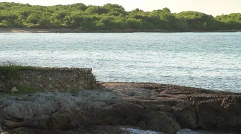 Stone structure on the beach with island in background Video stock 8763057