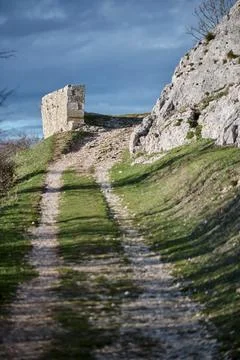 Stone structure on dirt path leading uphill with rocky terrain Stock Photos
