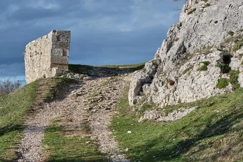 Stone structure on dirt path leading uphill with rocky terrain Stock Photos