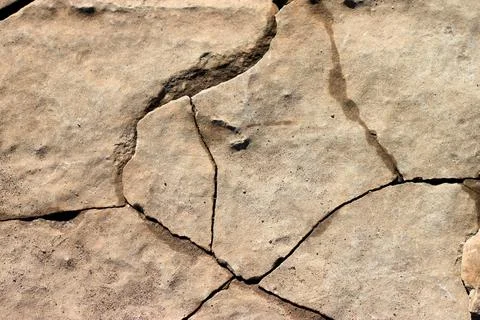Stone surface background. Cracks on the stone surface on a clear summer day. Stock Photos
