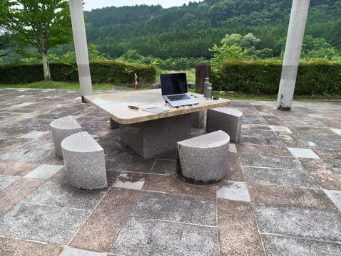 Stone table with laptop sits under open sky Stock Photos