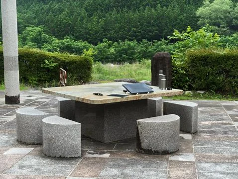 Stone table surrounded by matching stools Stock Photos