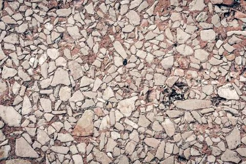 Stone texture of an old sidewalk made of small pieces of granite. Stock Photos