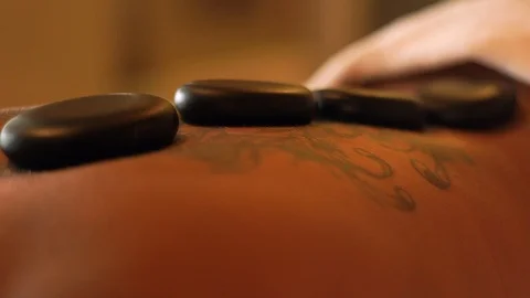 Stone therapy and back massage in spa. Close up stone massage female body while Stock Footage 102876887