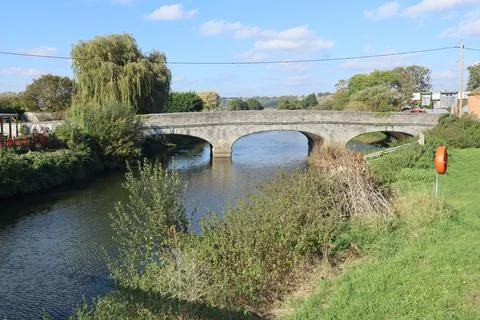 A stone three arch bridge over the River Parrett in Langport, Somerset as it  Stock Photos