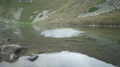 A stone thrown into a lake in the mountains. Throwing frogs on the water Stock Footage 231480194