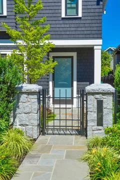 Stone tile paved pathway leading to the entrance door Stock Photos