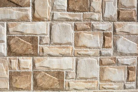 Stone tiles made of rectangular fragments of beige and sand color. Background Stock Photos