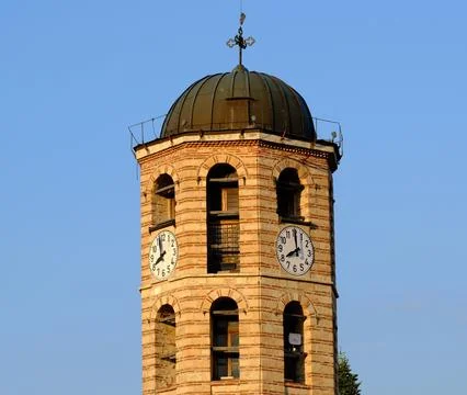 A stone tower with a clock and an Orthodox cross Stock Photos