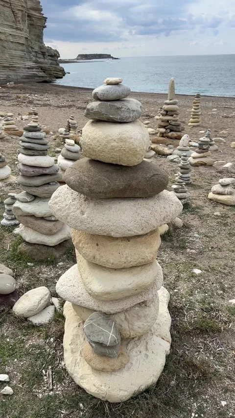 A stone tower found on a beach with many small, round pebbles. Beach with waves Stock Footage 301507720