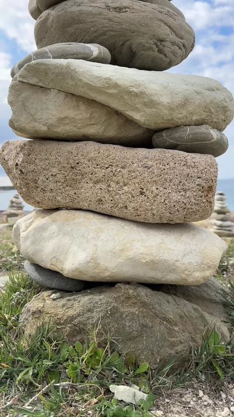 A stone tower found on a beach with many small, round pebbles. Beach with waves Stock Footage 301507870