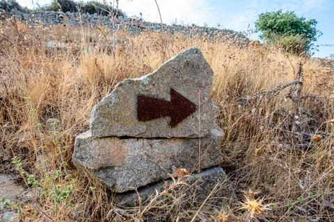 Stone trail marker with arrow in Corte France Stock Photos