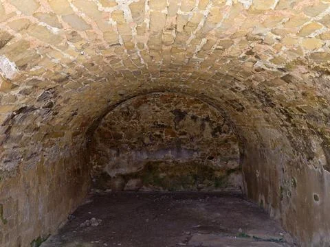 Stone vaulted cellar interior with curved brick ceiling, aged plaster walls.. Stock Photos
