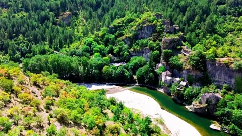 Stone Village on River Bend with Sandy Beach and Forested Cliffs Stock Footage 316609934