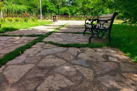 Stone walking path with overgrown grass between the slabs with the prospect.. Foto stock